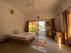 a bedroom with a bed and a sliding glass door at UKAYA VILLA in Paje