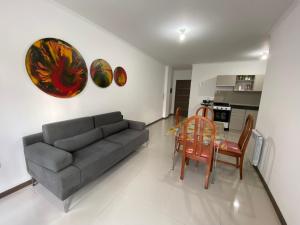 a living room with a couch and a table and chairs at Departamento con piscina en pleno centro in Villa Carlos Paz