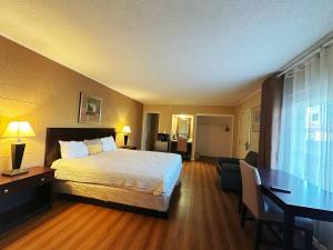 um quarto de hotel com uma cama e uma secretária em Royal Inn and Suites em Hemet