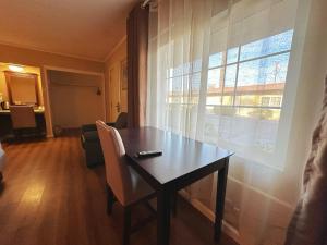 a dining room table with a chair and a window at Royal Inn and Suites in Hemet