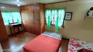 een woonkamer met een rode bank en een piano bij Kochimoto Homestay in Baguio
