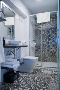 a bathroom with a shower and a toilet and a sink at Apartamentos Suites Cariátide in Plasencia