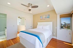 a bedroom with a white bed and a window at Bay View Beach House - Your Coastal Retreat in San Diego