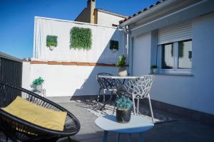 Un patio con sillas y una mesa en el balcón. en Apartamentos Suites Cariátide, en Plasencia