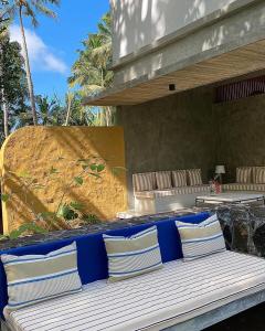 a bench with blue and white pillows on a patio at Maison Samara in Hikkaduwa