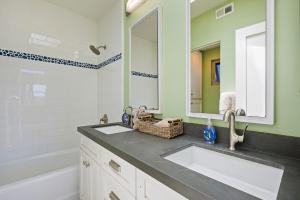 a bathroom with two sinks and a mirror and a tub at Bay View Beach House - Your Coastal Retreat in San Diego