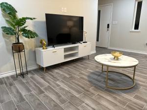 a living room with a flat screen tv and a table at Modern apt-King bed-Free parking-Wi-fi in Brownsville