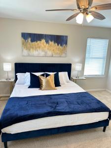 um quarto com uma cama azul e uma ventoinha de tecto em Modern apt-King bed-Free parking-Wi-fi em Brownsville