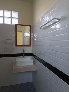 a white bathroom with a sink and a mirror at Sea Shell Beach Resort in Ko Lanta