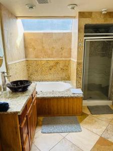een badkamer met een bad en een wastafel bij Family Fun Retreat Home with a Heart in Tualatin