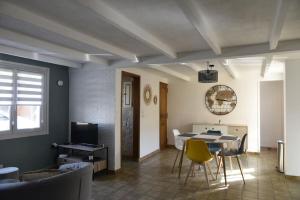 a living room with a table and yellow chairs at Gîte sur Grand Fort Philippe in Grand-Fort-Philippe