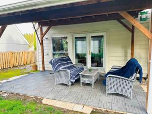 2 rieten stoelen en een tafel op een patio bij Family Fun Retreat Home with a Heart in Tualatin