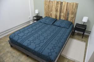 a bedroom with a blue bed with two night stands at Gîte sur Grand Fort Philippe in Grand-Fort-Philippe