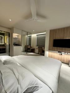 a bedroom with a large white bed with a flat screen tv at 32 Urban by Akoya Hotels in Hyderabad