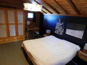 a bedroom with a white bed and a desk at Chalet Bortergade in Bellwald