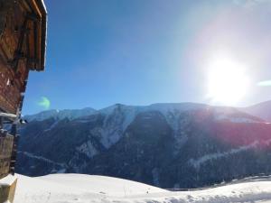 a view of a snowy mountain with the sun in the sky at Chalet Bortergade in Bellwald