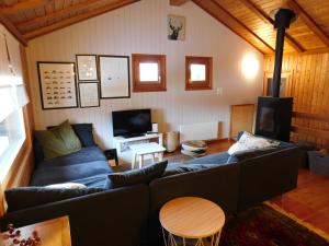 a living room with a blue couch and a tv at Chalet Bortergade in Bellwald
