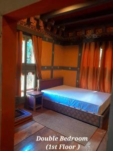 a bedroom with a bed in a room with windows at Nobgang B&B "Traditional Heritage HomeStay" in Punākha