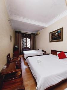 a hotel room with three beds and a table and chairs at Holiday Home in Hanoi