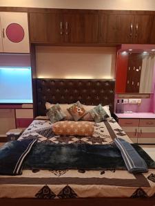 um quarto com uma cama grande e uma cabeceira castanha em Babylon - Luxurious yet Homely Facility em Guwahati