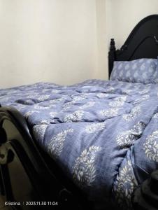ein Bett mit einer blauen und weißen Bettdecke darauf in der Unterkunft Christie's apartments Nairobi in Nairobi