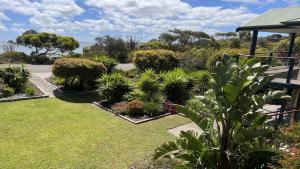 a garden with plants and trees and a building at Island View 2 in Coffin Bay