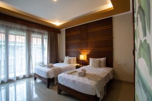 a hotel room with two beds and a window at Awatara Boutique Resort Ubud in Ubud