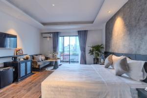 a bedroom with a large bed and a living room at Park View Luxury Hotel in Ho Chi Minh City