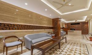 een lobby met een bank en een tafel en stoelen bij Treebo Trend Suvarna Comforts in Hassan