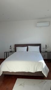 ローマにあるMaison Merulanaのベッドルーム1室(大型ベッド1台、白いシーツ、枕付)