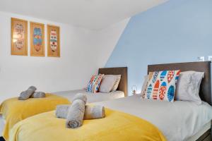 a bedroom with two beds with towels on them at The Surf Shack By My Getaways in Brighton & Hove