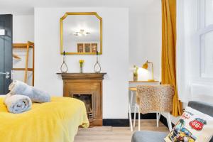a bedroom with a yellow bed and a mirror at The Surf Shack By My Getaways in Brighton & Hove