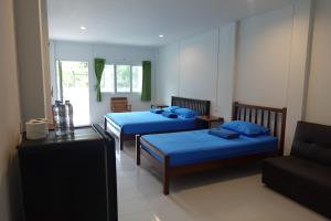 Habitación de hotel con 2 camas y sofá en Subsavet Village, en Baan Tai
