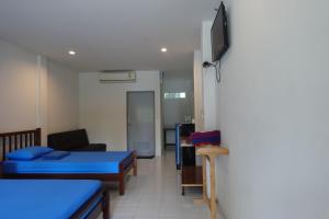 Habitación con 2 camas y TV en la pared. en Subsavet Village, en Baan Tai