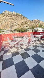 een groep stoelen en tafels op een geruite vloer bij Nahargarh Palace Hotel in Jaipur