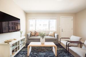 a living room with a couch and a tv at Seashore X by AvantStay Chic La Jolla Flat 5mins from the Beach in San Diego