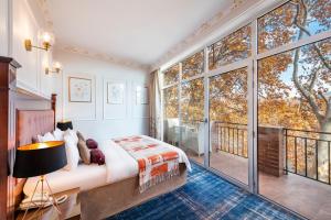 a bedroom with a bed and a balcony at River Side Hotel Tbilisi in Tbilisi City