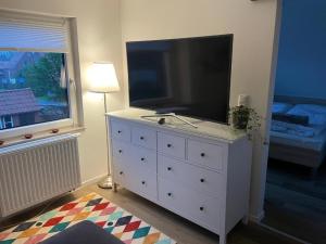 a white dresser with a large television on top of it at Apart-Offizier in Stick
