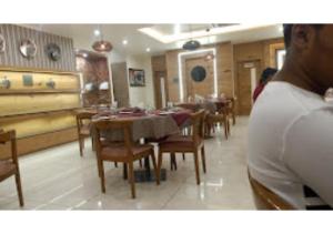 una sala da pranzo con tavoli e sedie in un ristorante di Hotel Giri Palace Madhya Pradesh a Tīkamgarh