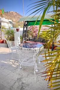 a white table and chairs with an umbrella at Nahargarh Palace Hotel in Jaipur