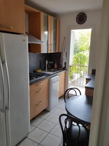 a kitchen with a white refrigerator and a table at Chambre A2 dans un appartement en colocation in Marseille