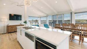 a kitchen and dining room with a view of the ocean at Dolphinview in Coffin Bay