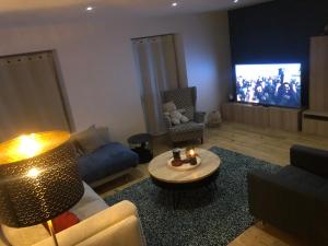 ein Wohnzimmer mit Sofa und Fernseher in der Unterkunft Maison de charme 6p Spa-Francorchamps - Jahlay - Idéale familles et week-ends in Jalhay