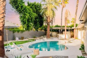 a swimming pool in a yard with palm trees at El Mirador by AvantStay Canyon Views Large Pool Outdoor Grill Games Permit4253 in Palm Springs