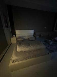 شقة أنيقة في العليا في الرياض: سرير كبير في غرفة مظلمة مع