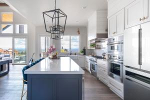 una cocina con armarios blancos y una isla azul en Pioneer by AvantStay Magnificent Home Located In The Brasada Ranch Community, en Powell Butte