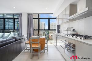 a kitchen with a couch and a table at MetaWise Sydney CBD Haymarket Luxe 2Bed Penthouse Bella in Sydney