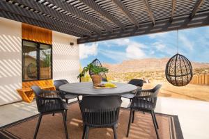 a patio with a table and chairs with a view at Chicory by AvantStay Modern Desert Retreat w Hot Tub in Joshua Tree