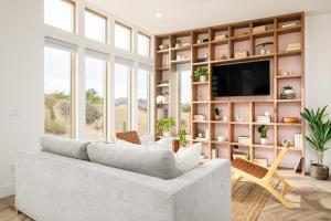 a living room with a couch and a tv at Chicory by AvantStay Modern Desert Retreat w Hot Tub in Joshua Tree