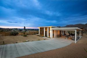 a house with a large patio in the desert at Chicory by AvantStay Modern Desert Retreat w Hot Tub in Joshua Tree